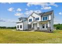 Two-story farmhouse with white siding, stone accents, and a large front porch at 1863 White Fawn Ln, Rock Hill, SC 29730