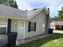 Exterior shot showing the side of the house, back door and pathway with trash cans in view at 212 W Bingham St, Statesville, NC 28677