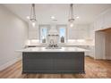 A modern kitchen with white cabinets, marble countertops, and pendant lighting for an elegant aesthetic at 225 Davidson Gateway Dr, Davidson, NC 28036