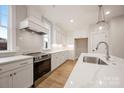 A modern kitchen with stainless steel appliances, white cabinets, and marble countertops at 225 Davidson Gateway Dr, Davidson, NC 28036
