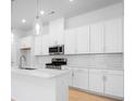 Gourmet kitchen features sleek white cabinets, stainless steel appliances, and stylish backsplash at 3107 Beacon Heights Rd, Indian Land, SC 29707