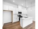 Modern kitchen with white cabinets, stainless steel appliances, an island, and hardwood floors at 3109 Beacon Heights Rd, Indian Land, SC 29707