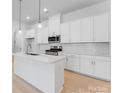 Bright kitchen featuring quartz countertops, stainless steel appliances, and stylish pendant lighting at 3111 Beacon Heights Rd, Indian Land, SC 29707