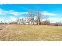 House situated on a large grassy lot with surrounding trees and road at 550 Woodleaf Barber Rd, Cleveland, NC 27013