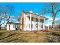 White farmhouse with a side view showcasing its porch and landscaping at 550 Woodleaf Barber Rd, Cleveland, NC 27013