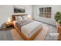 Virtually staged bedroom with large window and light wood bed frame at 6041 Pinebark Ct, Charlotte, NC 28212