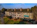 Condo building with multiple units, balconies, well maintained landscaping, and mature trees at 9801 Emerald Point Dr # 2, Charlotte, NC 28278