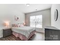 Spacious bedroom with a striped bedspread and plenty of natural light at 14207 Asbury Park Rd, Huntersville, NC 28078