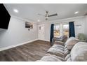 Cozy living room showcasing wood floors, a ceiling fan, a comfortable sofa, and natural light from the windows at 2752 Peachtree Rd, Statesville, NC 28625