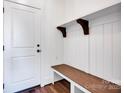 Mudroom featuring a wooden bench, hooks, and white wainscoting near the entrance at 421 Delburg Mill Alley Dr, Davidson, NC 28036