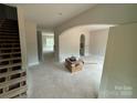 Unfinished living room featuring an arched entryway, doorway, and staircase with natural light at 426 Richards Ln, Mooresville, NC 28115