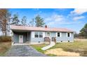 Cozy home featuring light blue siding, a red roof, a carport, and a welcoming front entrance at 4926 Nc Highway 109 South, Mount Gilead, NC 27306