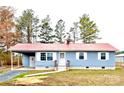 Inviting single-Gathering home with light blue exterior, red roof, carport, and neatly landscaped yard at 4926 Nc Highway 109 South, Mount Gilead, NC 27306