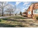 Side yard of brick house with trees and street at 107 E Boyd St, Maiden, NC 28650