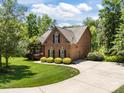 Beautiful brick home with a well-manicured lawn, mature landscaping, and an attached garage at 254 Streamside Pl, Mooresville, NC 28115