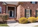 Elegant front entry with stone accents and black door at 254 Streamside Pl, Mooresville, NC 28115