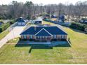 Expansive brick home featuring a large yard, detached garage, and mature trees at 7169 Pleasant Grove Rd, Charlotte, NC 28216