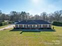 Beautiful brick home with a well-manicured lawn, a detached garage, and a basketball court at 7169 Pleasant Grove Rd, Charlotte, NC 28216