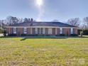 Charming brick home with a manicured lawn, symmetrical design and a covered front porch at 7169 Pleasant Grove Rd, Charlotte, NC 28216