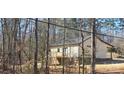 Back exterior view with a raised wooden porch, siding, and dark black windows and door frame at 107 Skyland Dr, Mount Gilead, NC 27306
