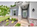 Inviting front porch with stone accents and a well-maintained garden, adding to the home's curb appeal at 15298 Windward Ln, Lancaster, SC 29720