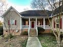 House with a red door, brick steps, and a wraparound porch at 2923 Meadow Creek Ln, Monroe, NC 28110