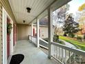 Front porch with white railings, red door and view of the yard at 2923 Meadow Creek Ln, Monroe, NC 28110