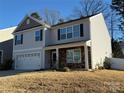Two-story house with gray siding, stone accents, and a two-car garage at 529 Elmwood Pond Ct, Charlotte, NC 28214