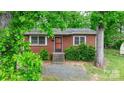 Front view of a red brick house with a yard and mature trees at 61 17Th Street Nw Pl, Hickory, NC 28601