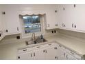 Bright kitchen featuring ample white cabinetry, stainless steel sink, and a window offering a view of the outdoors at 2044 Helen Dr, Gastonia, NC 28054