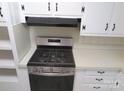 Modern kitchen featuring a stainless steel gas range with a built-in overhead vent hood, complete with ample countertop space at 2044 Helen Dr, Gastonia, NC 28054