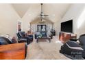 Spacious living room with vaulted ceilings, comfortable seating, and a large TV at 3406 Red Fox Trl, Weddington, NC 28104