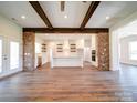 Open kitchen with white cabinets, a large island, and exposed wooden beams at 0000 Trull Hinson Rd, Wingate, NC 28174