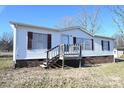 Front view of a white mobile home with brown shutters and a wooden deck at 3463 Rock Creek Dr, Newton, NC 28658