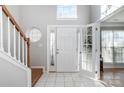 Bright entryway with tile floors, wooden staircase, and a white front door at 3625 Stonefield Sw St, Concord, NC 28027