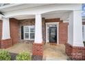 Inviting front porch with brick columns and a black front door at 4047 Blackburn Ct, Fort Mill, SC 29707