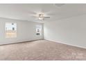 Spacious bedroom with neutral carpeting and two large windows at 103 Adams Tree Way, Troutman, NC 28166