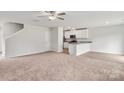 Open living space with kitchen island, stairs, and neutral carpeting at 103 Adams Tree Way, Troutman, NC 28166