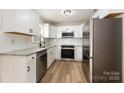 Modern kitchen featuring white cabinets, granite countertops, and stainless steel appliances at 123 Hemlock Dr, Salisbury, NC 28147