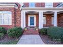 Brick home with a blue front door, white columns, and landscaping at 2010 Lake Forest Dr, Tega Cay, SC 29708