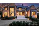 Elegant brick home with a grand entrance, highlighted by large windows, a modern staircase, and professional landscaping at 2103 Cortelyou Rd, Charlotte, NC 28211