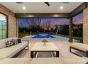Inviting outdoor living space with comfortable seating, offering a serene view of the stunning pool area and landscaped backyard at 2103 Cortelyou Rd, Charlotte, NC 28211