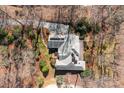 Stunning aerial view of a home nestled among trees, featuring a well-manicured lawn and a spacious driveway at 411 Major Run, Cramerton, NC 28032