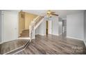 Spacious living room with gray walls, hardwood floors, and a staircase leading upstairs at 6303 Windsor Gate Ln, Charlotte, NC 28215