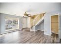 Bright living area with hardwood floors, featuring a view of the front yard and a staircase at 6303 Windsor Gate Ln, Charlotte, NC 28215