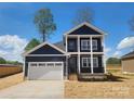 Beautiful two-story home with a two-car garage, dark navy siding, and white accents at 8078 Blackwood Rd, Denver, NC 28037