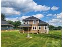 Beautiful backyard showcases a spacious porch and a lovely green yard under a partly cloudy sky at 8078 Blackwood Rd, Denver, NC 28037
