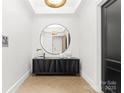 Elegant entryway with a large circular mirror and modern console table at 130 Cherokee Rd # 304, Charlotte, NC 28207