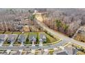 Aerial view showcasing the home's location with nearby road, wooded area and other homes at 2006 Houle Ln, Charlotte, NC 28214