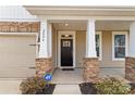 Covered front porch featuring stone columns, dark front door, and an ADT security system at 2006 Houle Ln, Charlotte, NC 28214
